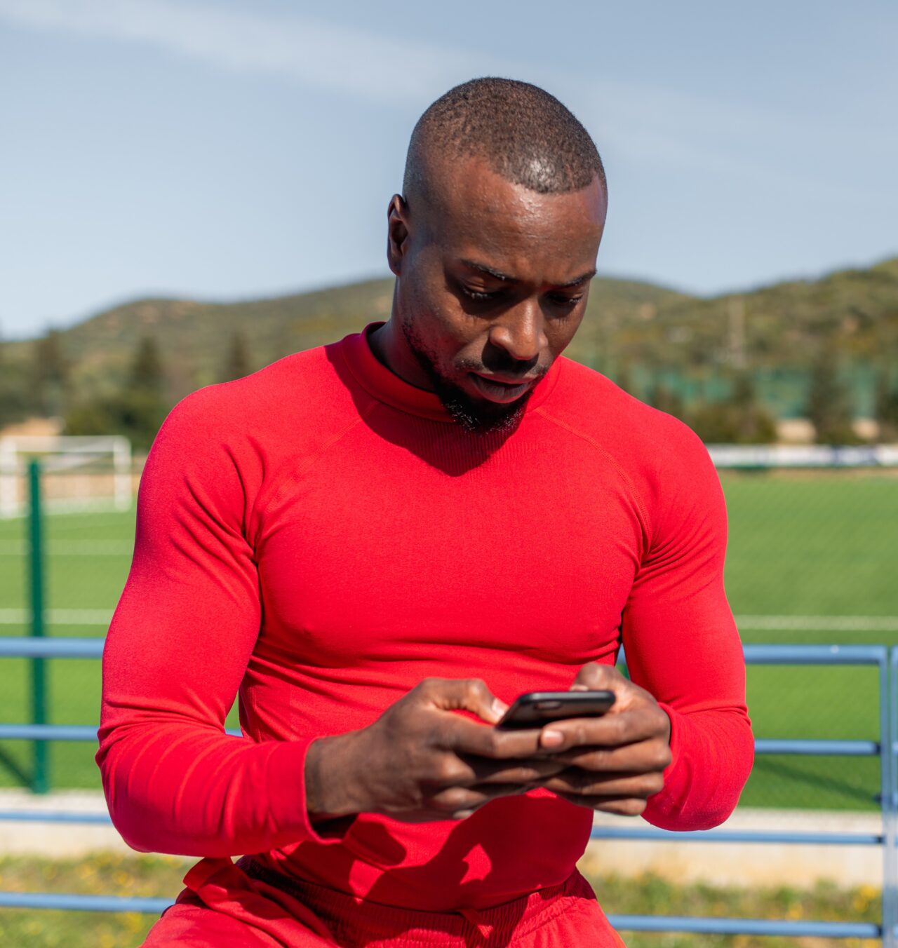 Contact Deon Lendore Foundation - athlete holding smartphone